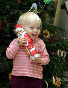 Glückliches kleines Kind mit Schokoladenweihnachtsmann