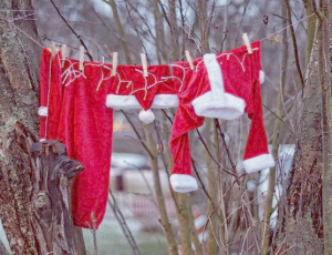 die rot-weißen Kleidungsstücke des Weihnachtsmanns sind an einer Wäscheleine im Wald zum Trocknen aufgehängt