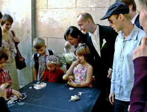 Hochzeitsgäste besichtigen eine Ausstellung mit von den Kindern hergestellten Kunstwerken