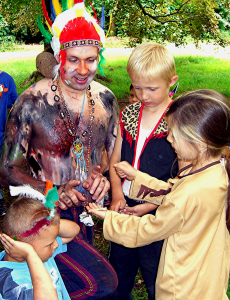 Medizinmann Weißer Uhu spielt mit Indianerkindern ein Ratespiel