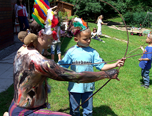 Weißer Uhu zeigt einem Kind, wie es Pfeil und Bogen richtig halten muss