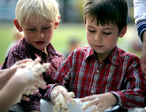 zwei Jungen kneten hingebungsvoll Salzteig in einer Emailleschüssel