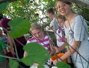 Kindercafé in einem Fahrrad-Iglu: ein Mädchen beim Anrühren einer Speise blickt in die Kamera