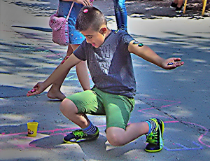 Ein Junge balanciert Kronkorken auf Armen, Schultern und Kopf