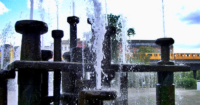Stadtrallye Berlin: sprudelnder Brunnen mit U-Bahn im Hintergrund